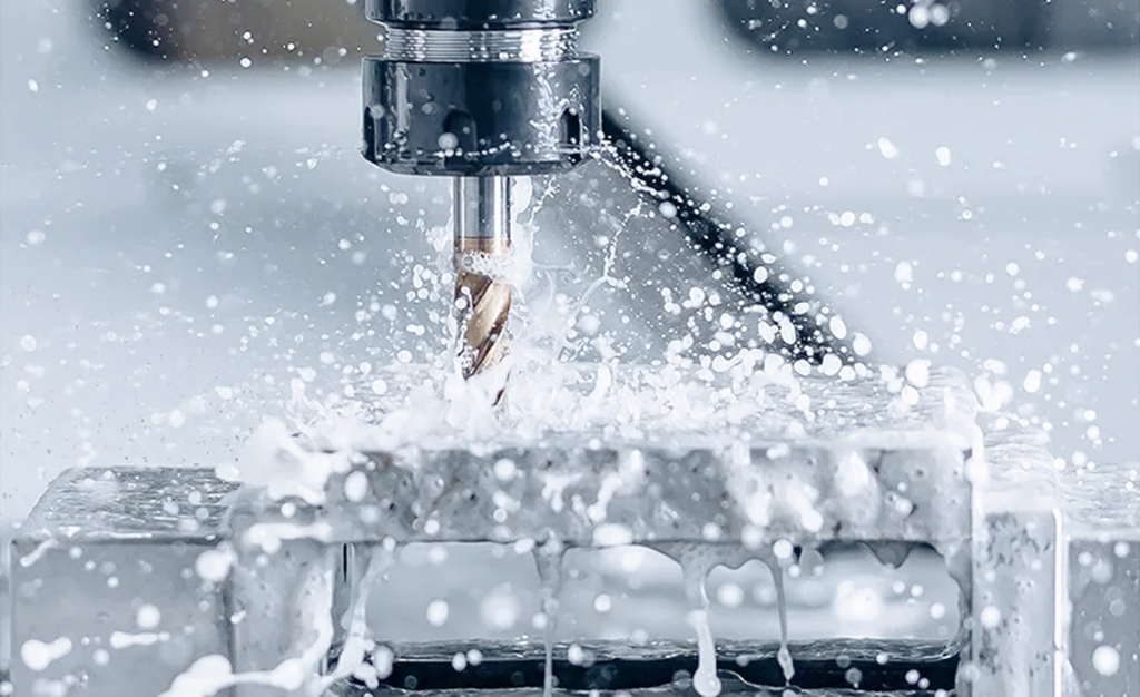 Close-up of a CNC milling spindle cutting into metal as coolant splashes around the workpiece.