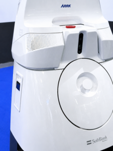 Close-up of a white SoftBank Robotics robot with a circular chest panel, sensors at the neck, and ARRK branding on the body.